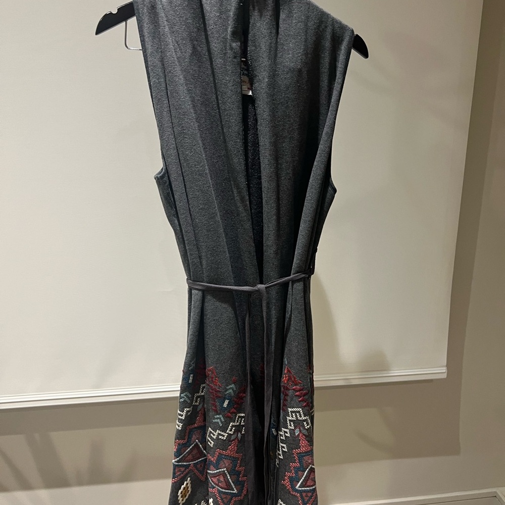 Long gray vest with detail on bottom. Waist belt